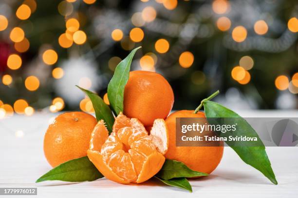several tangerines on table with bokeh lights - tangerine stock pictures, royalty-free photos & images