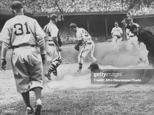 During a game against the Philadelphia Phillies, American baseball player Jackie Robinson , of the Brooklyn Dodgers, trapped between the first and...