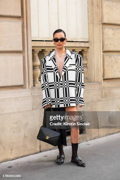 Alicia Roddy wears a Marni jacket, top and skirt, Ganni shoes, Chanel bag, Louis Vuitton earrings and black sunglasses during the Womenswear...