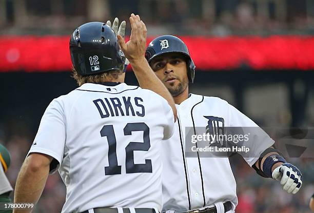 Omar Infante of the Detroit Tigers celebrates with teammate Andy Dirks after hitting a two run home run to left field in the second inning of the...
