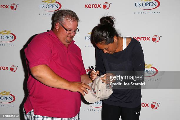 Jamie Hampton of the United States signs her autograph for a fan on Day One of the 2013 US Open at the 2013 US Open at the USTA Billie Jean King...