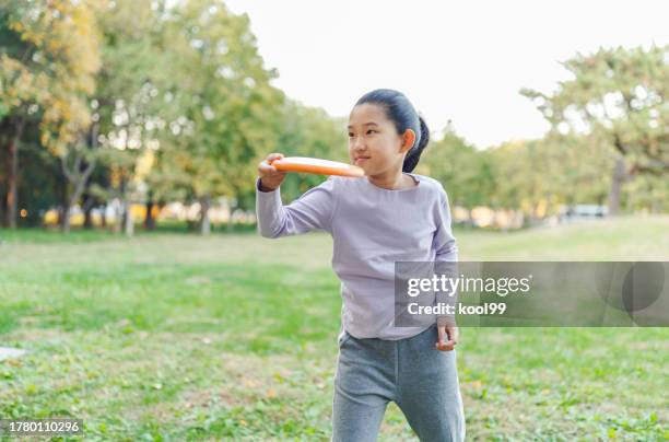 niña jugando frisbee - lanzar término deportivo fotografías e imágenes de stock