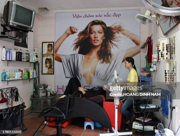 Woman enjoys a face massage at a beauty shop in Hanoi 12 December 2007. Thanks to economic growth, women pay more attention to their clothes, hair...