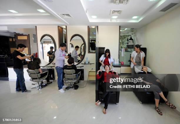 Hairdressers tend to their clients at "Boulbaba", one of the most famous beauty centres in Tunis, on May 13, 2011. Because of the city's nightly...