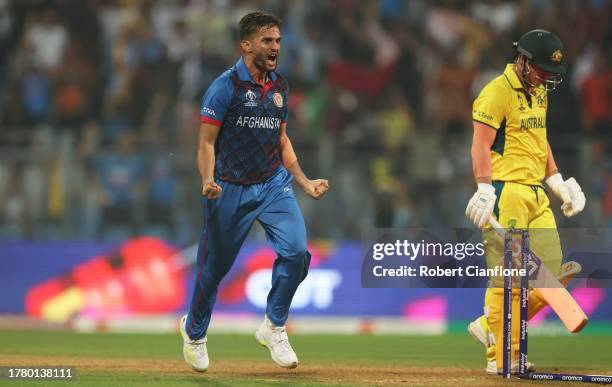 Azmatullah Omarzai of Afghanistan celebrates the wicket of David Warner of Australia during the ICC Men's Cricket World Cup India 2023 between...