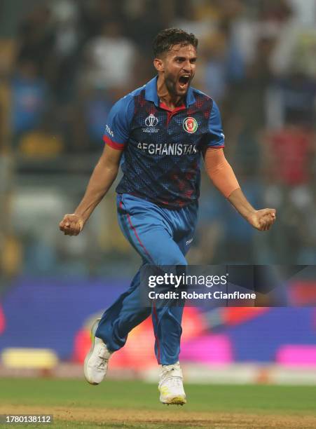 Azmatullah Omarzai of Afghanistan celebrates the wicket of David Warner of Australia during the ICC Men's Cricket World Cup India 2023 between...