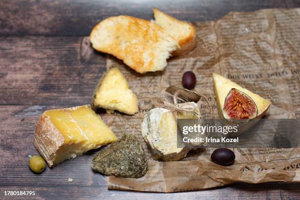 cheese set with olives and figs on the craft paper - hard cheese stock pictures, royalty-free photos & images