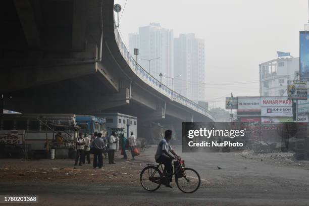 People are standing at a bus stand on a smoggy morning in Kolkata, India, on November 12, 2023. Kolkata is the third most air-polluted city in India,...