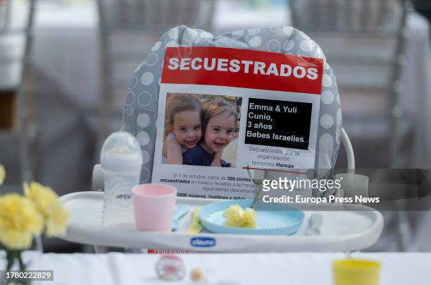 Baby chair with a photo of two kidnapped Israeli girls, on a table with 241 empty chairs to symbolize the wait for the return of the hostages...