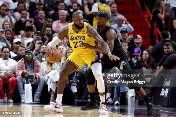 LeBron James of the Los Angeles Lakers drives against Jimmy Butler of the Miami Heat during the fourth quarter of the game at Kaseya Center on...