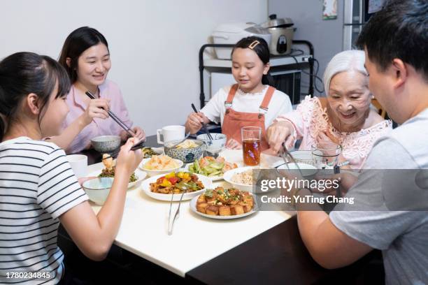 chinese family having lunch at home - yuting stock pictures, royalty-free photos & images