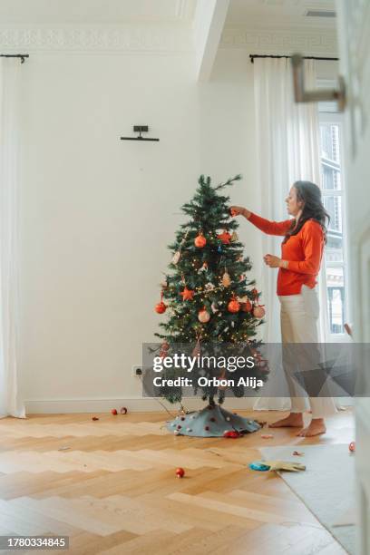 happy family decorating christmas tree - decorating the christmas tree stock pictures, royalty-free photos & images