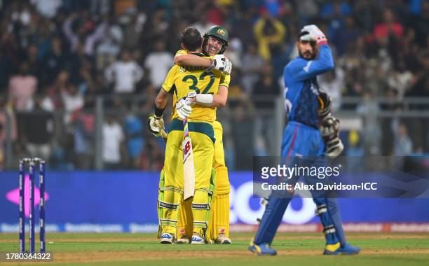 Glenn Maxwell of Australia celebrates with team mate Pat Cummins after hitting a six for the winning runs, finishing unbeaten on 201 not out during...