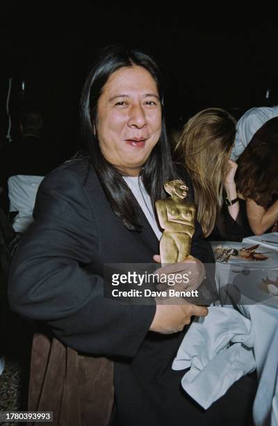 Chinese-Irish designer John Rocha holding his award at London Fashion Week, London, 18th October 1993.