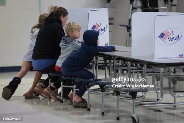 Voter casts her ballot accompanied by three children at Haymarket Elementary School November 7, 2023 in Haymarket, Virginia. With control of...