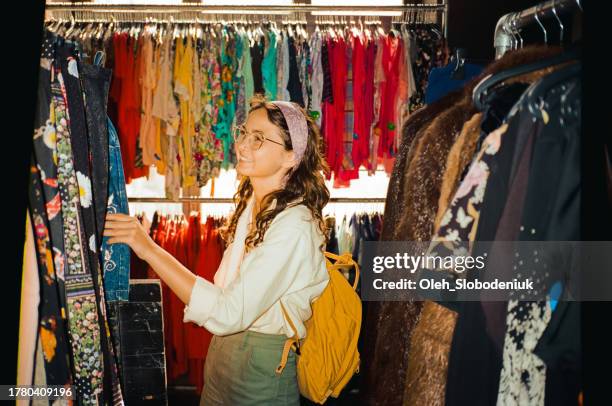 cheerful woman shopping in thrift shop in berlin - só mulheres jovens imagens e fotografias de stock