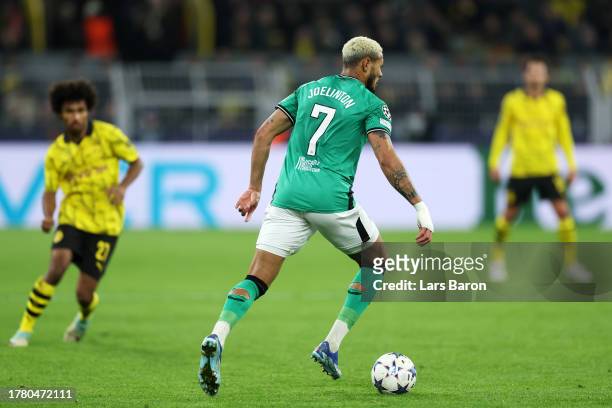 Joelinton of Newcastle United runs with the ball as holes in the back of his socks are seen during the UEFA Champions League match between Borussia...