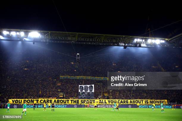 Borussia Dortmund fans hold a banner up reading 'You don't care about the sport - All you care about is money!' during the UEFA Champions League...