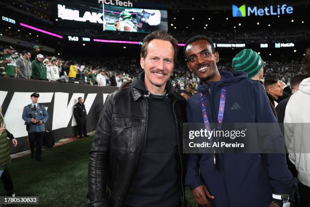 Patrick Wilson and NYC Marathon winner Tamirat Tola attend the Los Angeles Chargers vs New York Jets Monday Night Football game at MetLife Stadium on...