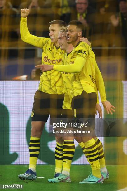 Julian Brandt of Borussia Dortmund celebrates with teammates Nico Schlotterbeck and Felix Nmecha after scoring the team's second goal during the UEFA...