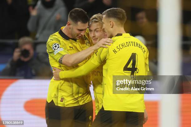 Julian Brandt of Borussia Dortmund celebrates with teammates Niklas Suele and Nico Schlotterbeck after scoring the team's second goal during the UEFA...