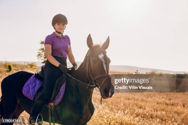 a beautiful young woman is enjoying and riding a horse in the nature - pet silhouette stock pictures, royalty-free photos & images