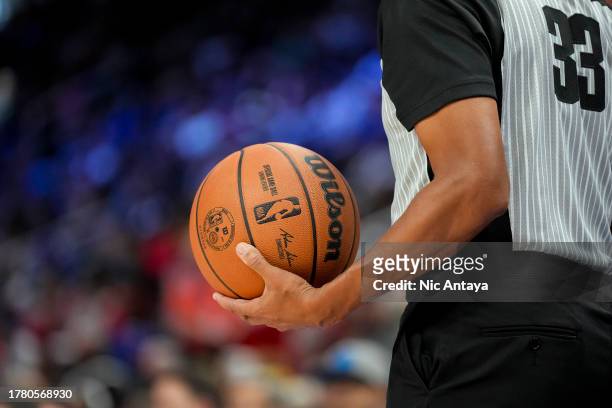 Referee Sean Corbin holds a Wilson brand NBA basketball during the game between the Detroit Pistons and Golden State Warriors at Little Caesars Arena...
