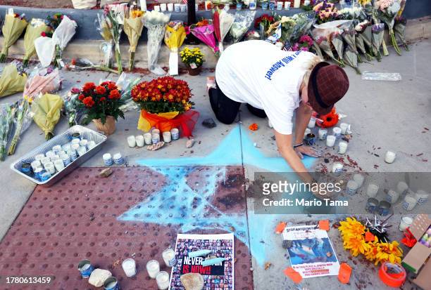Elena Colombo creates a Star of David at a makeshift memorial at the site of an altercation between 69-year-old Paul Kessler, who was Jewish, and...