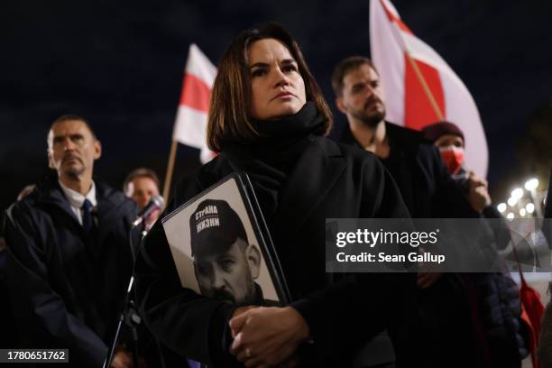 Belarusian political opposition in exile leader Svetlana Tikhanovskaya clutches a folder with a portrait of her husband, jailed opposition figure...