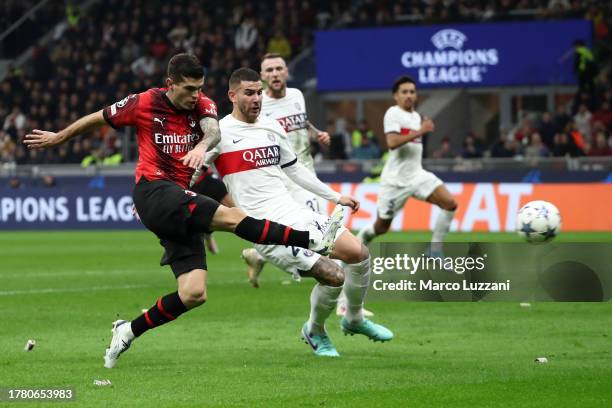 Christian Pulisic of AC Milan shoots whilst under pressure from Lucas Hernandez of Paris Saint-Germain during the UEFA Champions League match between...