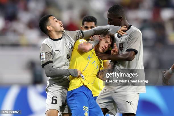 Khaled Mohammed and Almoez Ali of Al Duhail fight with Otavio Monteiro of Al-Nassr during AFC Champions League match between Al Duhail and Al-Nassr...