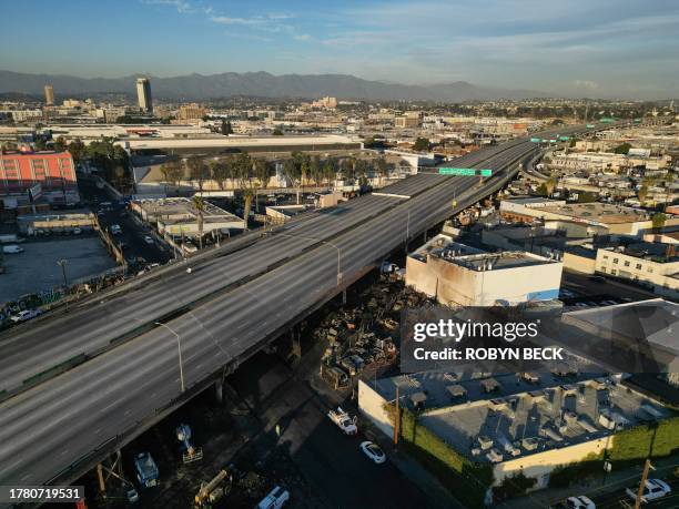 An aerial picture taken on November 13, 2023 shows burnt cars and other debris under the I-10 freeway after a large fire led to the shutdown of the...