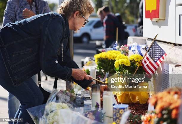 Person lights a candle at a makeshift memorial at the site of an altercation between 69-year-old Paul Kessler, who was Jewish, and pro-Palestinian...