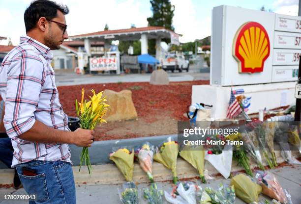 Person prepares to place flowers at a makeshift memorial at the site of an altercation between 69-year-old Paul Kessler, who was Jewish, and...