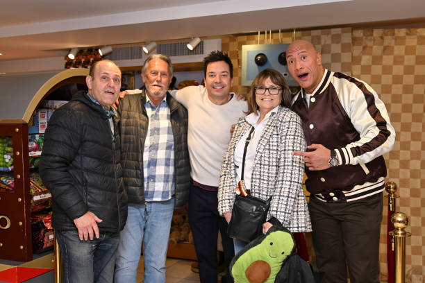 Episode 1874 -- Pictured: Host Jimmy Fallon and actor Dwayne Johnson with a family during the FAO Schwarz Surprise Giveaway on Monday, November 13,...