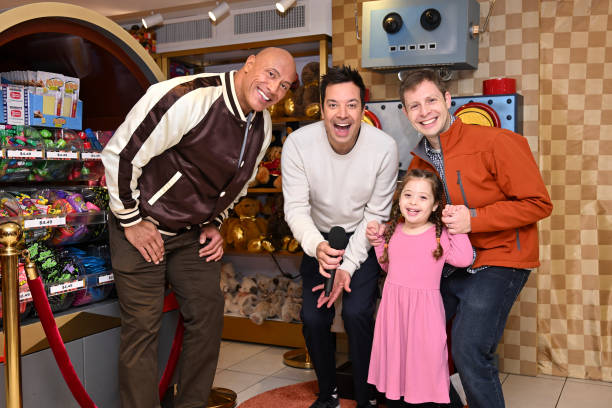 Episode 1874 -- Pictured: Actor Dwayne Johnson and host Jimmy Fallon with a family during the FAO Schwarz Surprise Giveaway on Monday, November 13,...