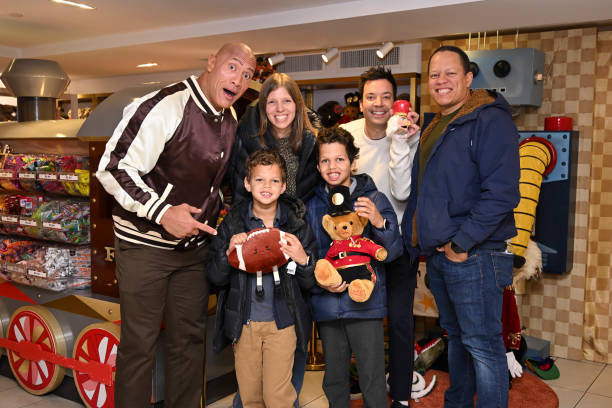 Episode 1874 -- Pictured: Actor Dwayne Johnson and host Jimmy Fallon with a family during the FAO Schwarz Surprise Giveaway on Monday, November 13,...