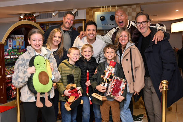 Episode 1874 -- Pictured: Host Jimmy Fallon and actor Dwayne Johnson with a family during the FAO Schwarz Surprise Giveaway on Monday, November 13,...