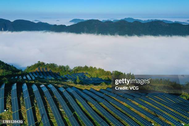 Aerial view of wind turbines and solar panels at a wind and solar hybrid power generation plant on a mountain on October 30, 2023 in Chongqing, China.