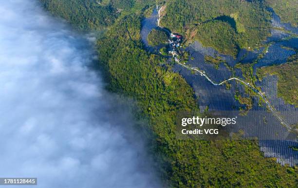 Aerial view of wind turbines and solar panels at a wind and solar hybrid power generation plant on a mountain on October 30, 2023 in Chongqing, China.