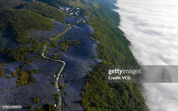 Aerial view of wind turbines and solar panels at a wind and solar hybrid power generation plant on a mountain on October 30, 2023 in Chongqing, China.