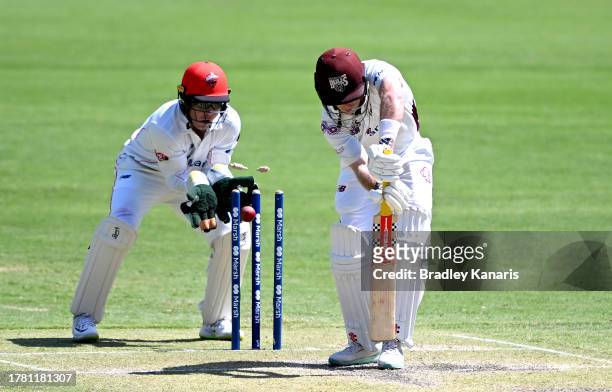 Jimmy Peirson of Queensland is bowled out by Nathan McSweeney of South Australia during day three of the Sheffield Shield match between Queensland...