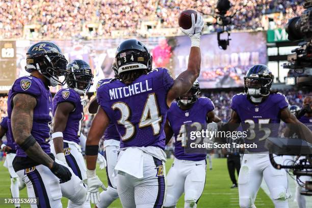 Keaton Mitchell of the Baltimore Ravens celebrates with teammates after scoring his first NFL touchdown during the second half against the Seattle...