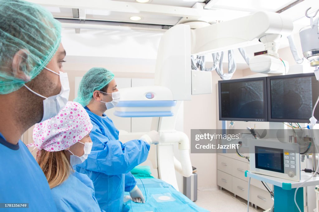 Team of doctors performing angiography operation in a modern hospital. Operating room.
