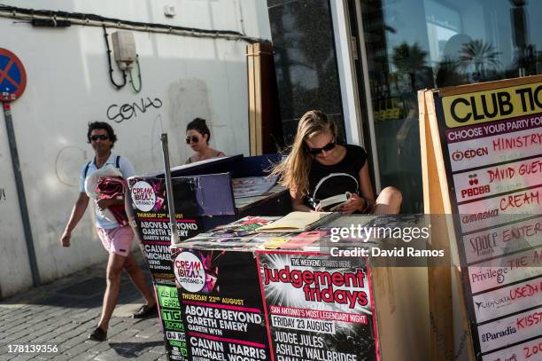 Promotions girl reads a book as she works at a club ticket stall in San Antonio on August 22, 2013 in Ibiza, Spain. The small island of Ibiza lies...