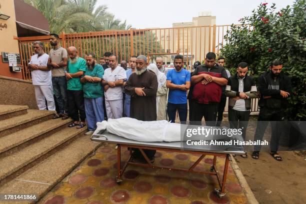 People mourn a child as they collect the bodies of Palestinians killed in Israeli air raids on November 8, 2023 in Khan Yunis, Gaza. Heavy fighting...