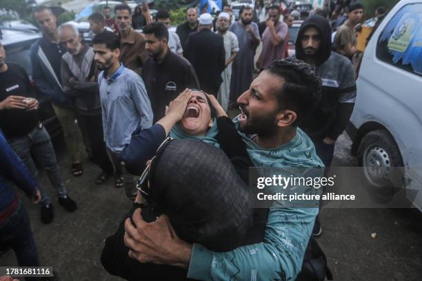 November 2023, Palestinian Territories, Khan Yunis: Women mourn for the victims who were killed in Israeli bombardment, ahead of their burial outside...