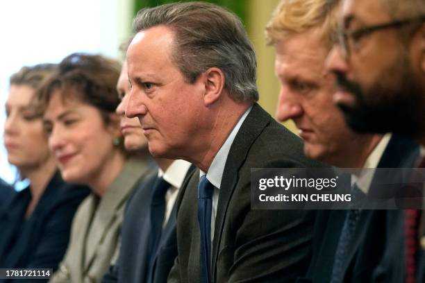 Britain's new Foreign Secretary David Cameron , sits with Britain's Leader of the House of Commons Penny Mordaunt , Britain's Health Secretary...