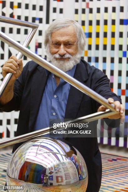 Photo of Agam Yaacov, Israeli artist, poses with one of his pieces at the Georges Pompidou Art Center 28 June 2003 in Paris where his works of...