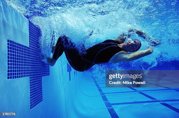 Female swimmer performing racing turn in competition, underwater view.
